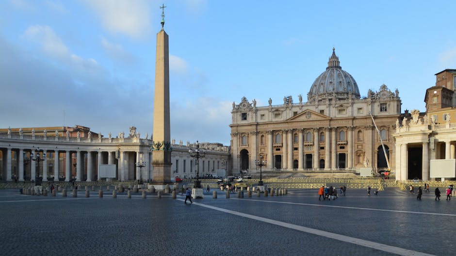 Vatican City view featuring St. Peter's Basilica, obelisk, and colonnades on a sunny day.