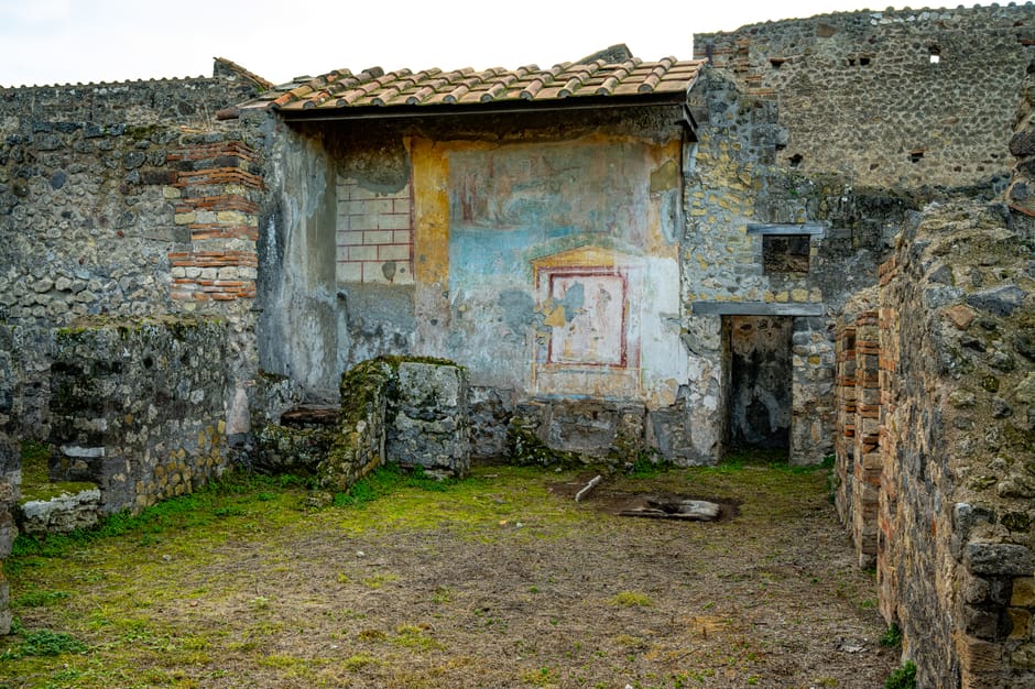 Explore the historic ruins of Pompei, showcasing a colorful fresco on ancient walls.