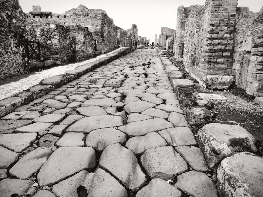 Explore the preserved ancient cobblestone street in Pompeii, Italy, showcasing Roman architecture.