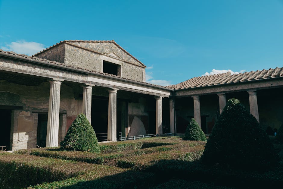 Explore the well-preserved ruins of a Roman courtyard in Pompeii under a clear blue sky.