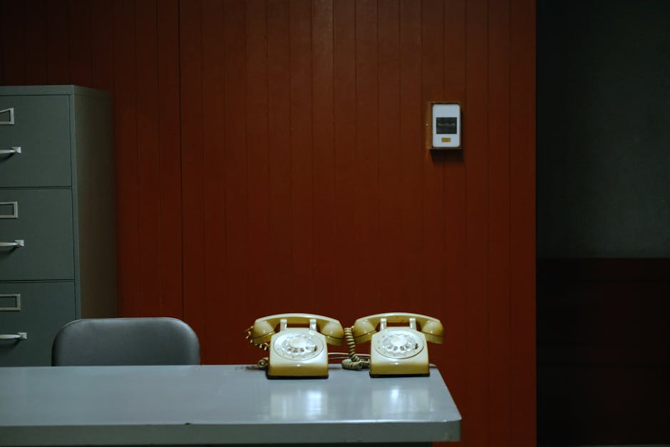 Retro office setup with rotary phones, file cabinet, and red wood paneling in Ho Chi Minh City's Independence Palace.